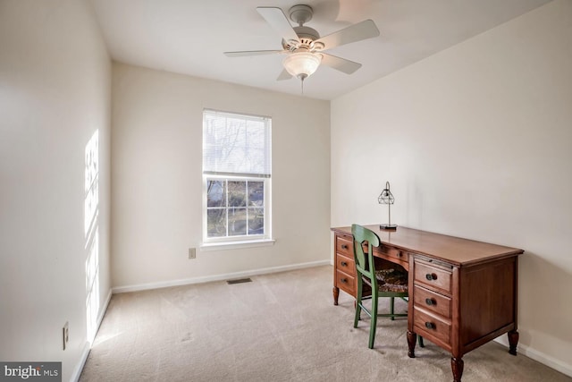 home office with a ceiling fan, light colored carpet, visible vents, and baseboards