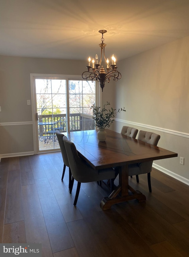 dining area featuring an inviting chandelier, baseboards, and hardwood / wood-style floors