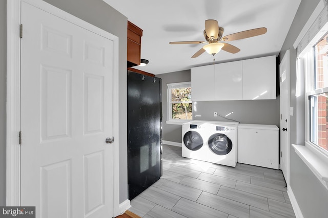 washroom featuring cabinets, washing machine and clothes dryer, ceiling fan, and light hardwood / wood-style flooring