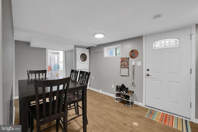 dining room featuring wood-type flooring and stacked washer / drying machine