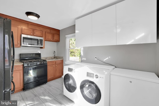 interior space featuring sink, washer and dryer, and light tile patterned flooring