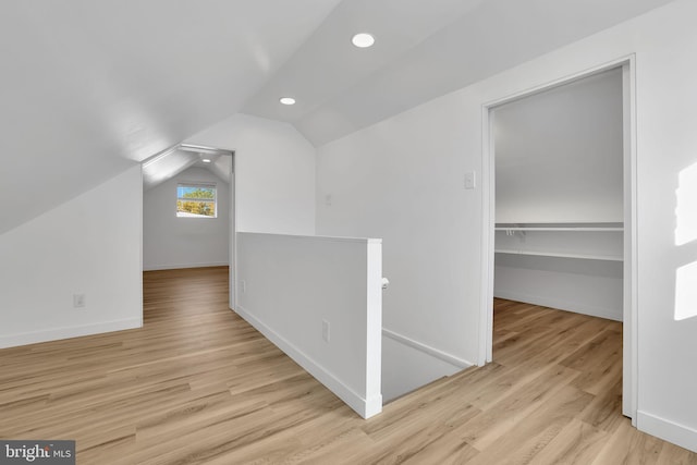 additional living space featuring light hardwood / wood-style floors and vaulted ceiling