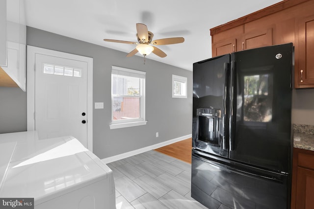 kitchen featuring light hardwood / wood-style floors, ceiling fan, washer / clothes dryer, and black fridge with ice dispenser