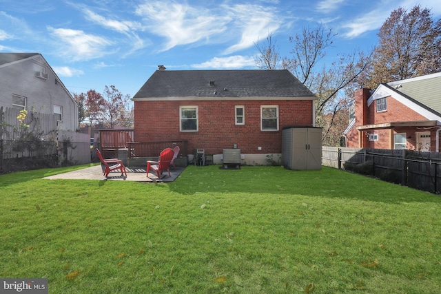 back of property featuring a storage unit, a patio, and a yard