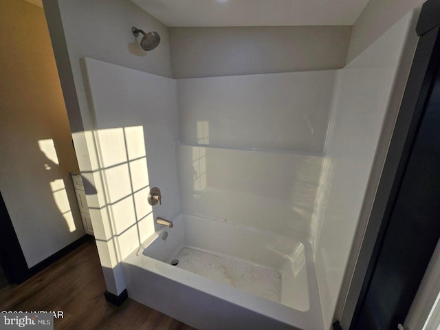 bathroom featuring hardwood / wood-style floors and bathtub / shower combination