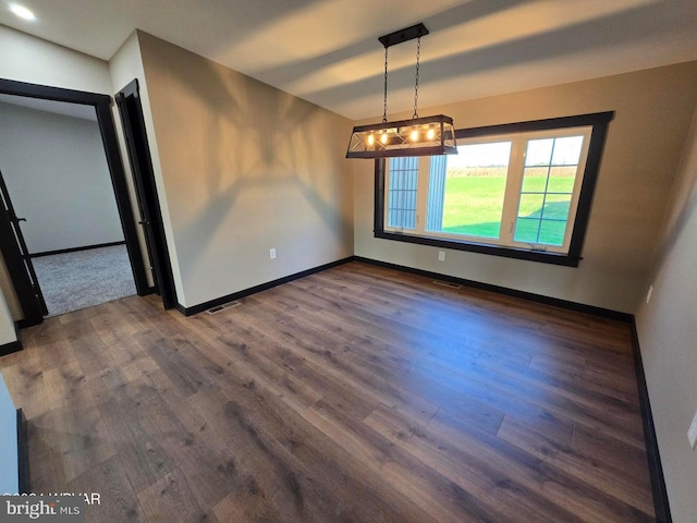 unfurnished dining area featuring dark wood-type flooring