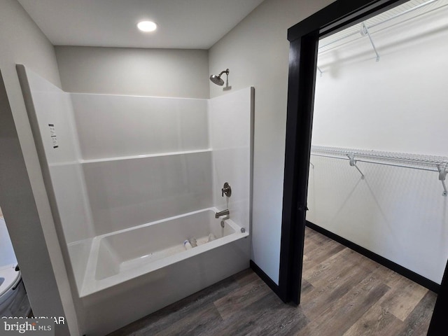 bathroom featuring bathing tub / shower combination and hardwood / wood-style flooring