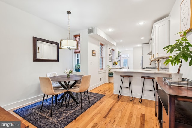 dining area with light hardwood / wood-style floors and sink