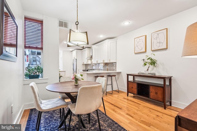 dining space with light hardwood / wood-style floors and sink