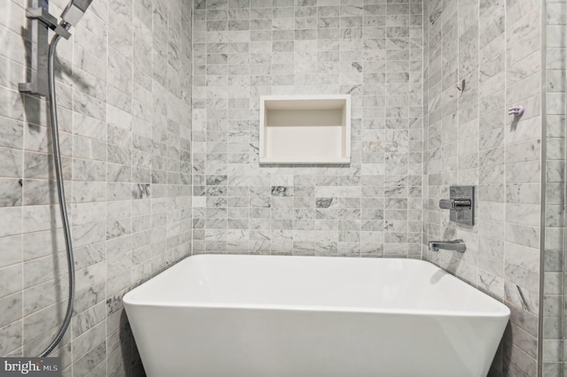 bathroom with a bathing tub and tile walls