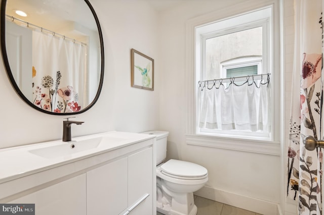 bathroom with tile patterned flooring, vanity, and toilet