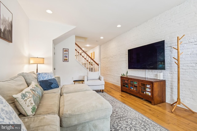 living room featuring hardwood / wood-style floors and brick wall