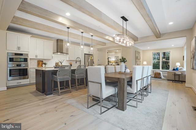 dining space with light wood finished floors, beam ceiling, recessed lighting, and baseboards