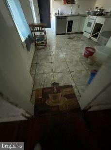 kitchen featuring dishwasher, sink, tile patterned floors, and white stove