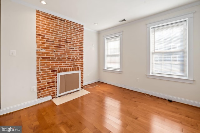 unfurnished living room with ornamental molding, hardwood / wood-style floors, and a fireplace