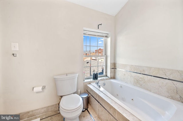 bathroom with tiled bath, tile patterned floors, and toilet