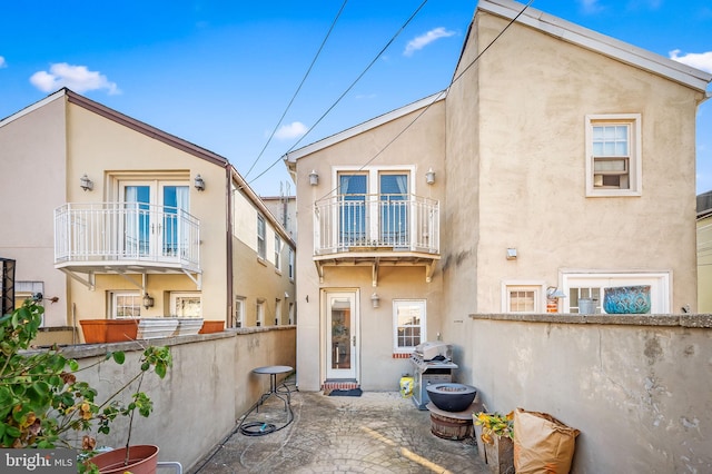 rear view of house with a balcony and a patio area