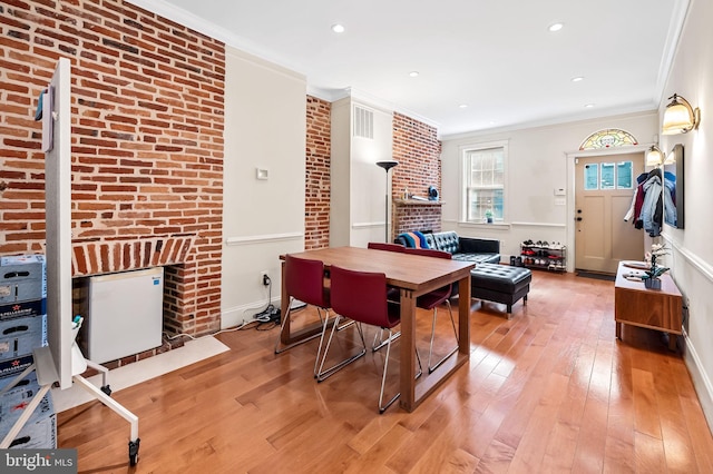 interior space featuring a fireplace, brick wall, and crown molding