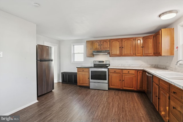 kitchen with dark hardwood / wood-style floors, sink, backsplash, and appliances with stainless steel finishes