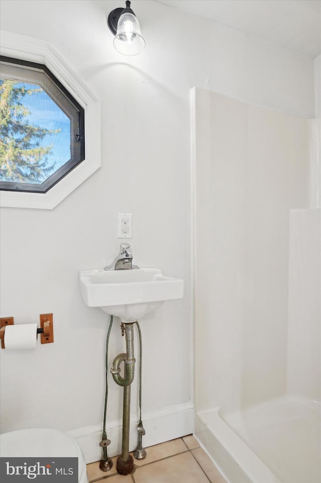 bathroom featuring walk in shower, tile patterned flooring, and toilet