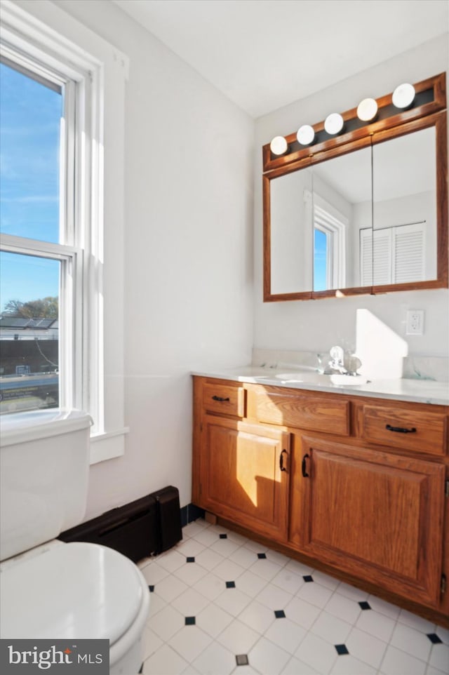 bathroom featuring plenty of natural light, vanity, and toilet