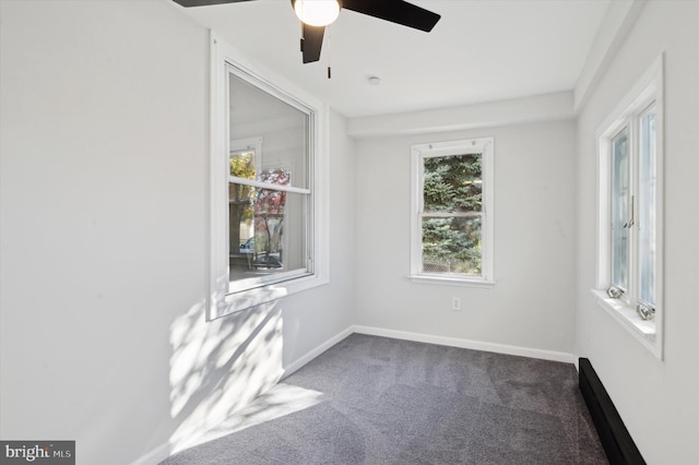 spare room with dark colored carpet and ceiling fan