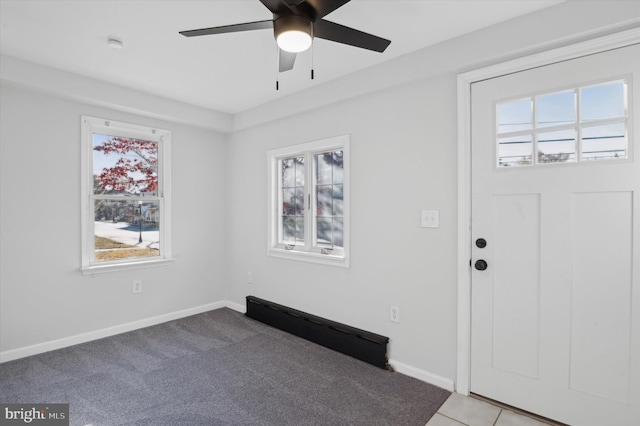 carpeted foyer entrance featuring a wealth of natural light and ceiling fan