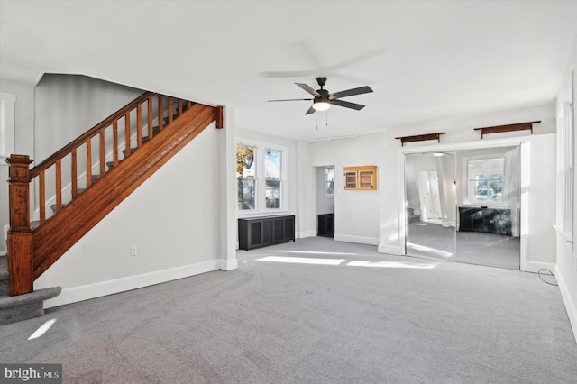 unfurnished living room featuring light colored carpet and ceiling fan