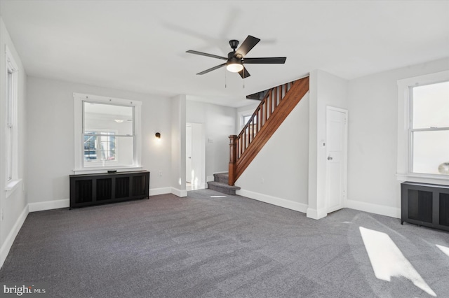 unfurnished living room featuring dark colored carpet, radiator heating unit, and ceiling fan