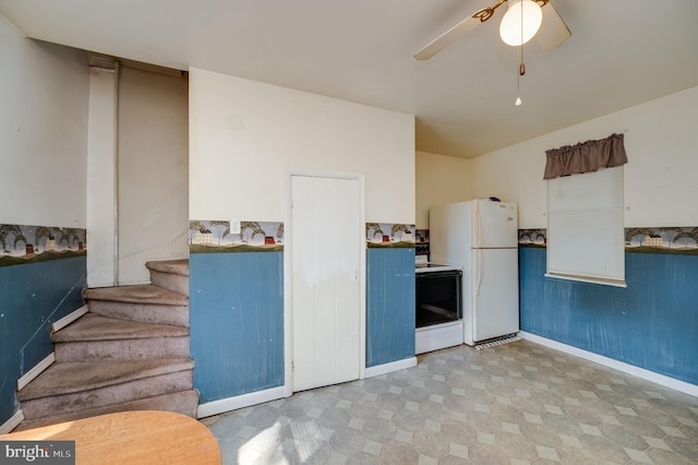 kitchen with ceiling fan, black range, and white refrigerator