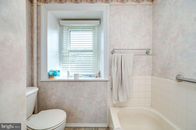 bathroom featuring a bath and toilet