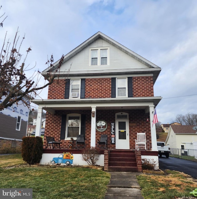 view of front of property with cooling unit, a front lawn, and a porch