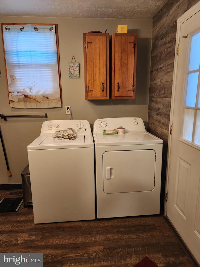 laundry area with separate washer and dryer, plenty of natural light, cabinets, and dark wood-type flooring