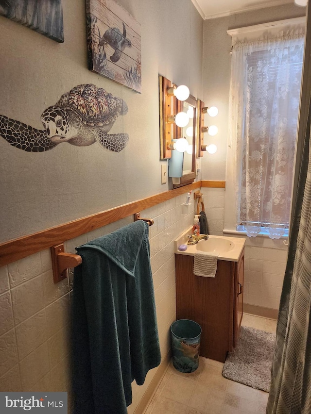 bathroom featuring vanity, tile patterned floors, tile walls, and crown molding