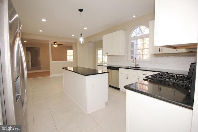 kitchen featuring pendant lighting, a center island, white cabinets, sink, and stainless steel appliances