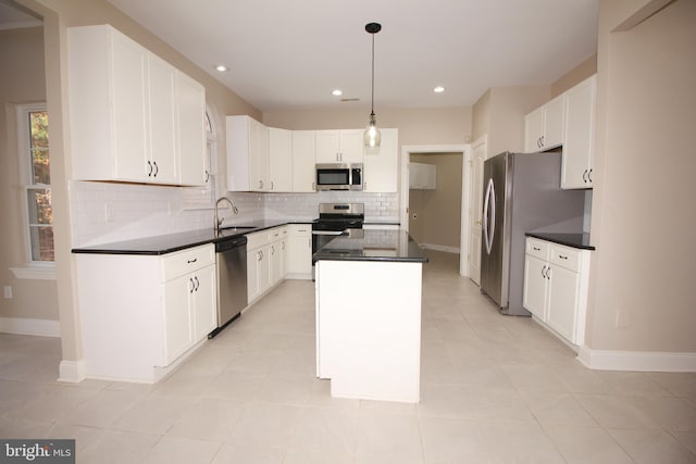 kitchen with white cabinets, pendant lighting, a kitchen island, and stainless steel appliances