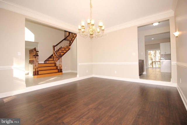 unfurnished room featuring hardwood / wood-style floors, crown molding, and an inviting chandelier