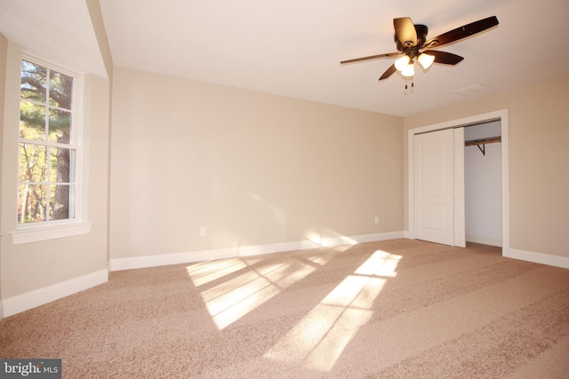 unfurnished bedroom featuring ceiling fan, a closet, and carpet