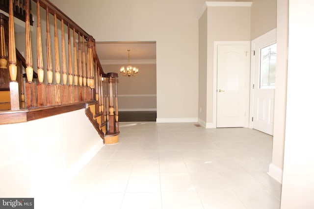 stairs with tile patterned flooring, ornamental molding, and an inviting chandelier