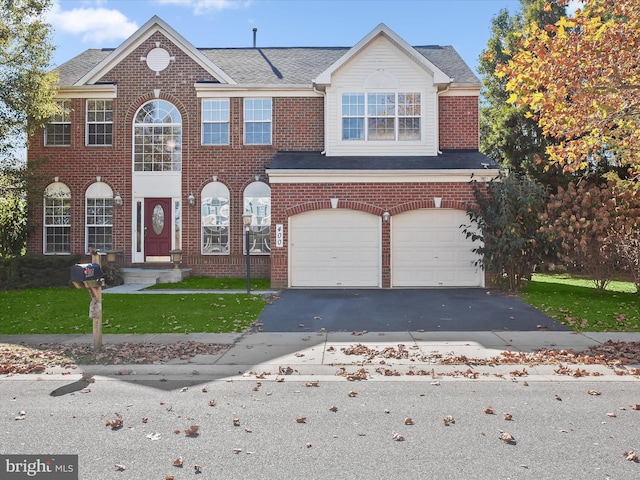 townhome / multi-family property featuring a garage and a front yard