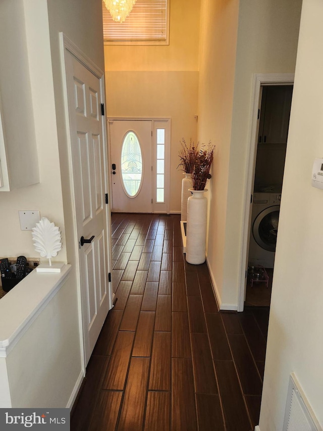 entryway featuring dark hardwood / wood-style flooring, washer / clothes dryer, and a notable chandelier