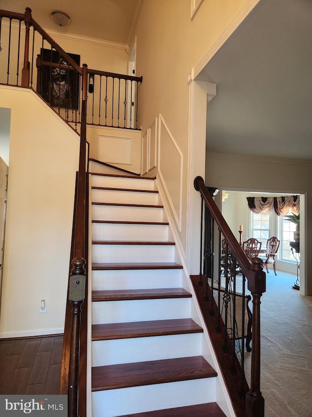 stairs with carpet flooring and ornamental molding