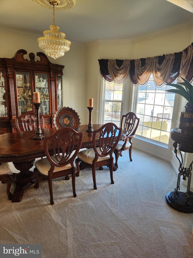 dining area with a chandelier, carpet, and ornamental molding