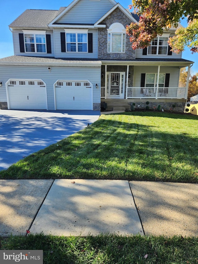 view of front of property with a garage, a porch, and a front lawn