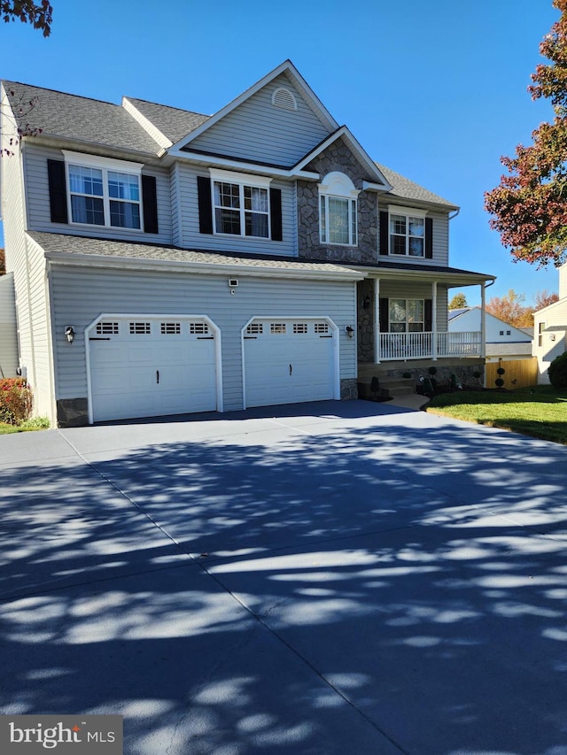 view of property with a garage and a porch