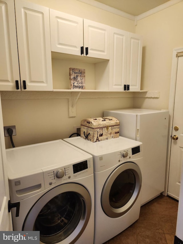 washroom with cabinets, washer and dryer, dark tile patterned flooring, and ornamental molding