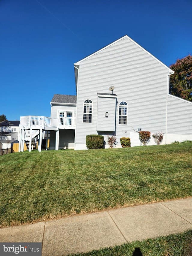 back of house featuring a lawn and a deck