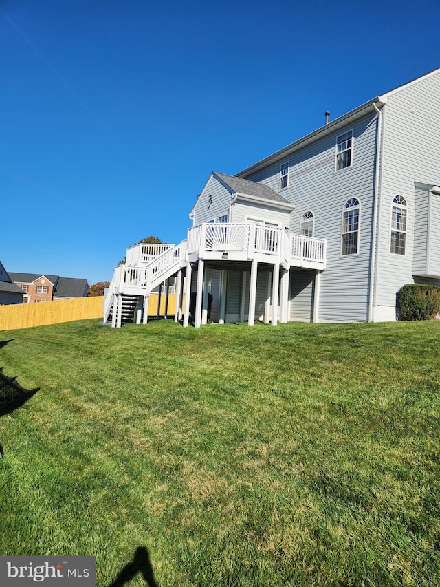 back of house with a lawn and a deck