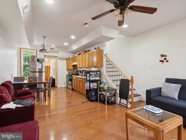 living room with ceiling fan and light hardwood / wood-style flooring