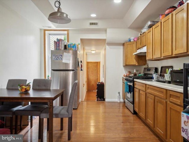 kitchen featuring appliances with stainless steel finishes and light hardwood / wood-style flooring